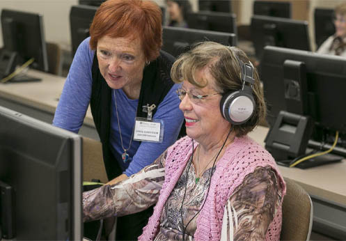 a NOCE instructor helping an older student use the computer