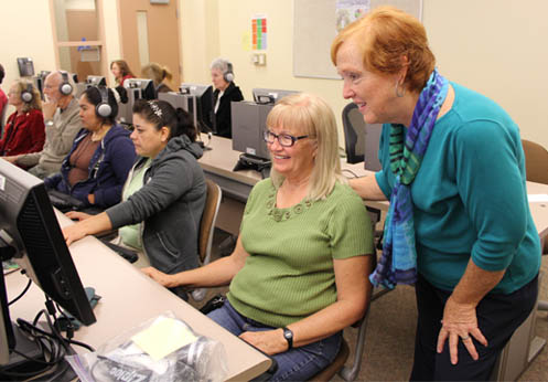A NOCE instructor helping an older adult’s student to use the computer.