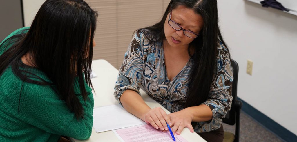 A photo of an academic tutor assisting a student with their assignment