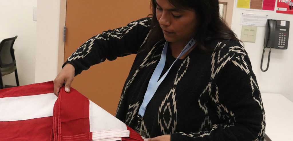 A funeral service student learning how to fold an American flag appropriately. 